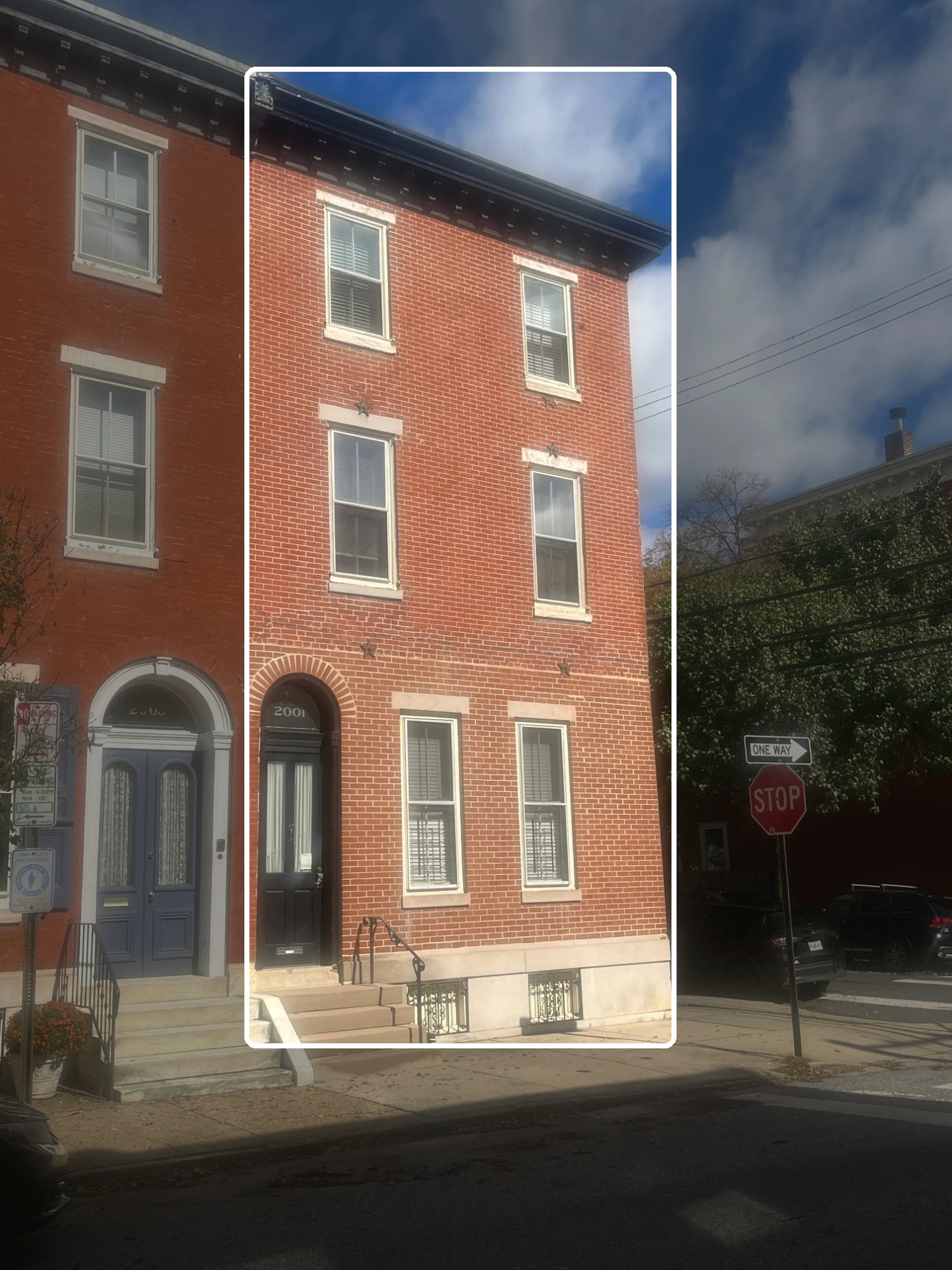 Brick multifamily building with arched doorway in Philadelphia, with one building outlined